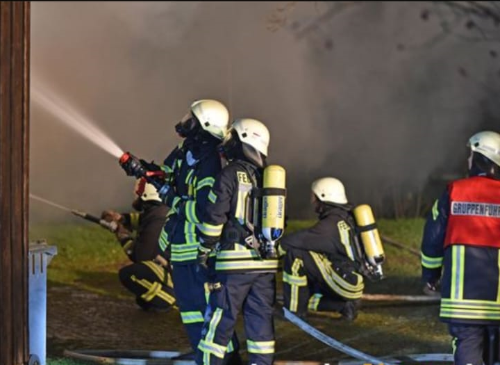 Feuerwehrleute in voller Montur löschen einen Brand, symbolisiert den engagierten Einsatz der Feuerwehr Hochkirch.