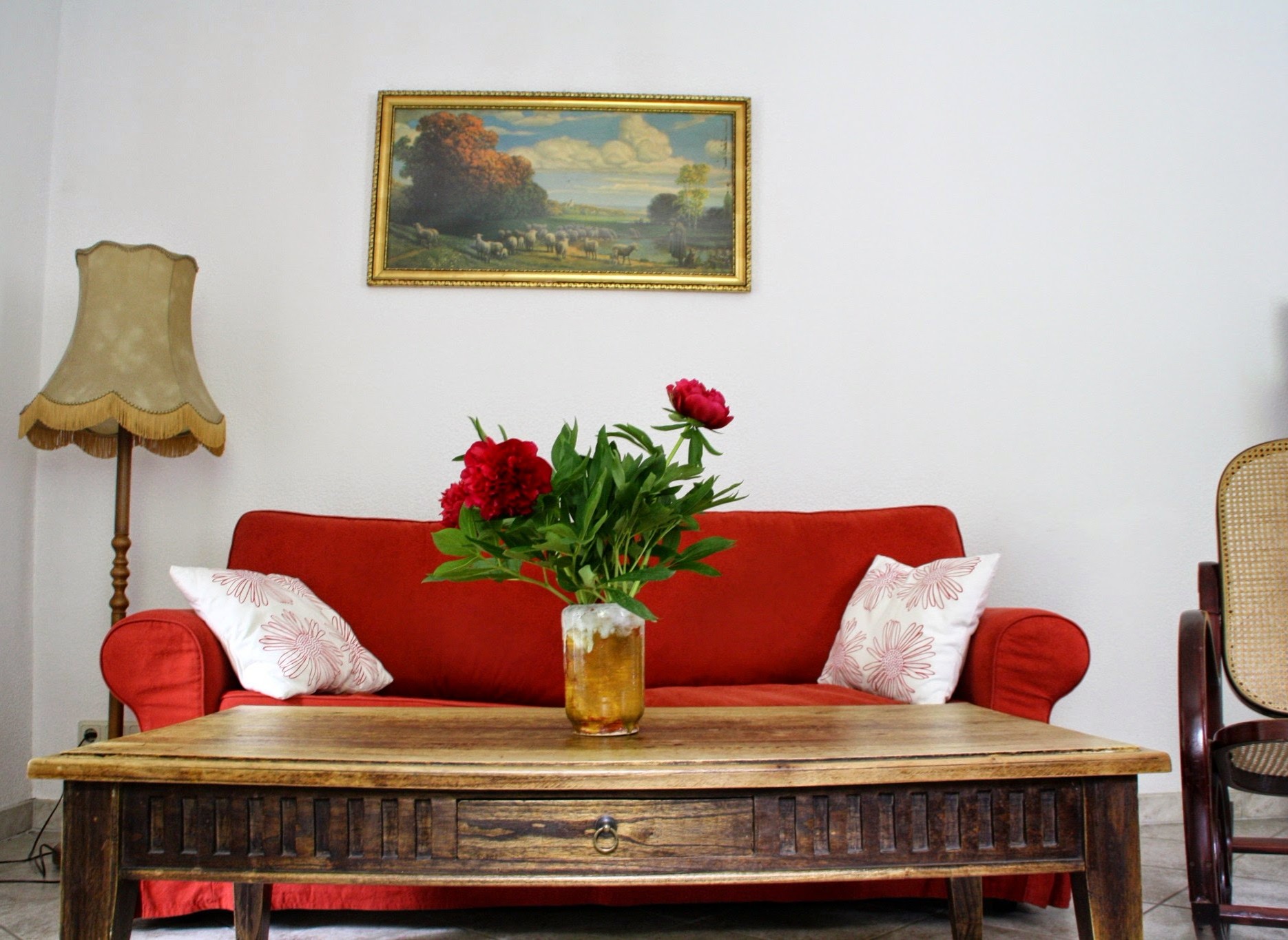 Ferienhof Kühn OT Steindörfel Nr. 7 02627 Hochkirch - Rotes Sofa und davor steht ein Holztisch mit einer Blume drauf